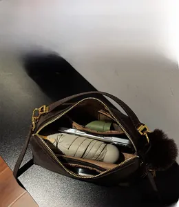 Innenansicht der braunen Umhängetasche mit Platz für Handy, Regenschirm und Kosmetik