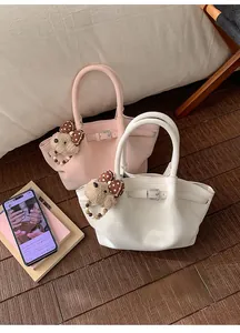 Detalle de los bolsos bombonera plisados en rosa y blanco con bonitos colgantes de osito