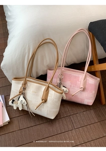 Détail de sacs cabas à carreaux tissés avec breloques cheval et logo doré élégant