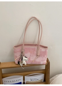 Détail du sac cabas en toile rose avec lanières en cuir et breloque petit poney