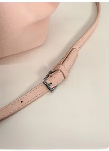 Detalle de correa de hombro ajustable de cuero con hebilla metálica plateada en el bolso