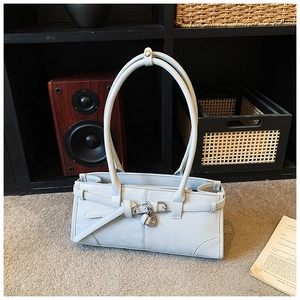 Detailed close-up of light blue rectangular handbag featuring three decorative buckled straps
