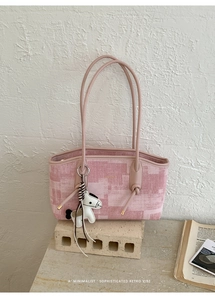 Détail de sac porté épaule en jacquard rose avec motifs géométriques et pendentif