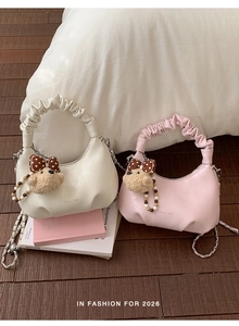 Detail of cream and pink crescent bags with ruffled handles and cute bear charms