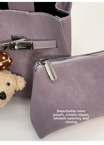 Detail view of purple bucket bag featuring a removable matching zipper pouch and metal lock