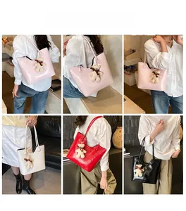 Detail of minimalist patent leather tote bags with bear pendant in four various colors