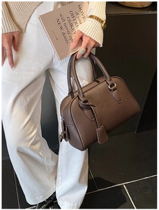 Dettaglio della borsa bowling in pelle martellata marrone scuro con modella