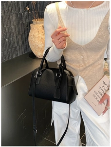 Dettaglio borsa Boston nera in pelle martellata con manici tondi e fibbie argento