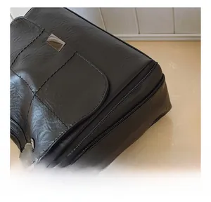 Detail of black leather tote bag showing quilted stitching and metal hardware accents