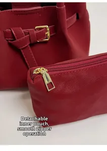 Detail view of the red bucket bag with a removable inner pouch and gold hardware