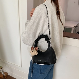 Black crescent chain bag with scrunchie handle and cute bear charm shown on model