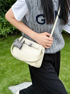 Bolso bandolera de cuero granulado blanco crema con cierre metálico y colgante de poni