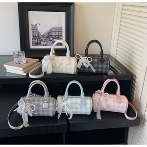 Détail de sacs cylindriques à damier en cinq couleurs avec charmes perle et dentelle