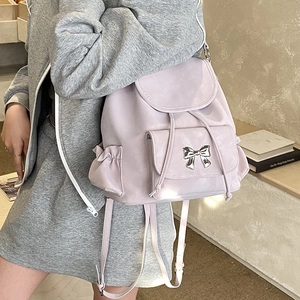 Detail of light purple drawstring backpack with metallic bow and soft matte texture
