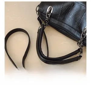 Detail showing adjustable strap with black chain hardware on quilted leather shoulder bag