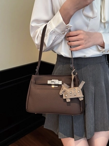 Bolso de mano en cuero marrón oscuro con cierre plateado y detalle de dije de caballo