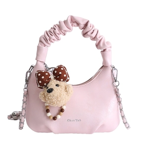 Stylish pink faux leather baguette bag with pleated handle and plush bear charm