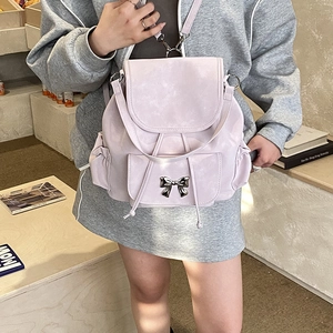 Detail of lavender matte backpack featuring a silver metal bow and drawstring closure