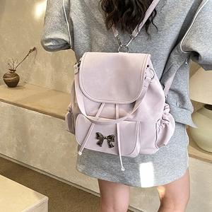 Detail of taro purple backpack featuring a decorative metal bow and drawstring closure