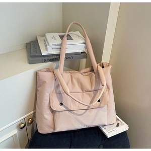 Detail of light pink large tote bag with front pocket and round button accents