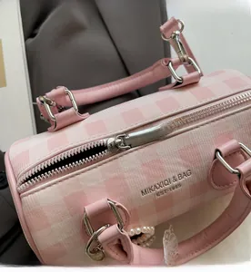 Détail du sac Boston à carreaux rose et blanc montrant le zip et le charme de perles