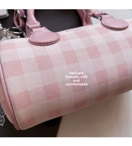 Détail du sac Boston à carreaux roses montrant la texture tissée et le pendentif perle