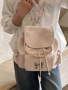 Minimalist light pink backpack with metallic bow detail and drawstring closure for women