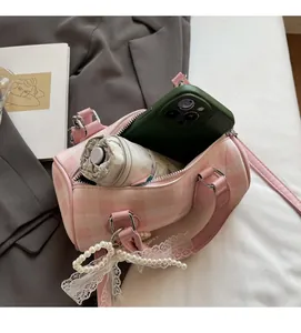 Vue détaillée de l'intérieur du sac rose à carreaux avec espace pour téléphone et parapluie