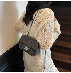 Detail of grey quilted tweed crossbody bag with silver chain strap and metal turn-lock