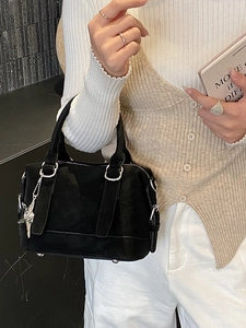 Elegant black suede handbag with star pendant and silver hardware shown with casual outfit