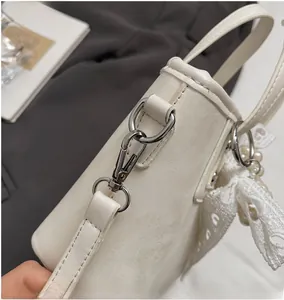 Dettaglio della borsa a secchiello in pelle PU bianca con anello a D e moschettone in metallo