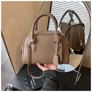 Dettaglio della borsa boston marrone in pelle martellata con lucchetto e manici robusti