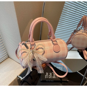 Détail du sac cylindre à carreaux roses avec un grand nœud en dentelle perlée