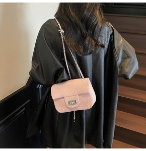 Rear view of a pink quilted chain shoulder bag worn with a black leather jacket