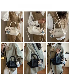 Detail of stylish bucket bag showing white and black variants with cute bear charms