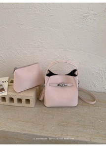 Detail of pink bucket bag set with matching pouch and silver metal buckle accents