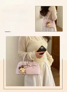 Pink boston bag with decorative buckle strap and plush bear charm for casual daily wear