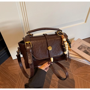 Détail du sac vintage marron avec perles en bois colorées et fermoir doré