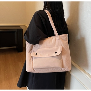 Detail of dusty pink large capacity canvas tote bag with front pocket and wide shoulder strap