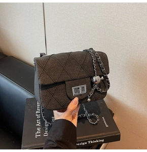 Detail of tweed crossbody bag featuring diamond quilting and silver turn-lock clasp