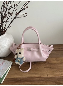Detail of light pink PU leather bucket bag with cute bear charm and silver buckle strap