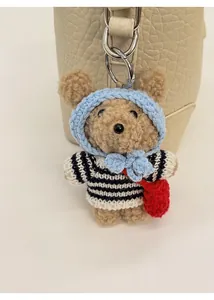 Close-up of a brown teddy bear charm with blue crochet hood on a lychee pattern bag