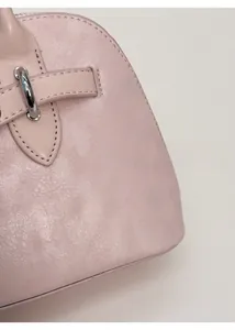 Detail of pink matte leather texture with silver metal D-ring on the shoulder bag