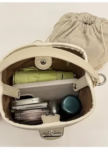 Top view showing the spacious interior and inner canvas pouch of the beige bucket bag