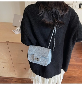 Close-up of quilted denim chain bag with silver twist lock on a shoulder strap