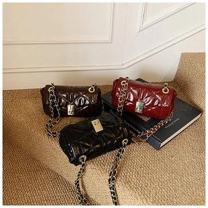 Close-up of quilted chain bags in black, burgundy and coffee with gold twist locks