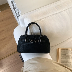 Close-up of black matte leather boston bag with metal eyelet and ring buckle details