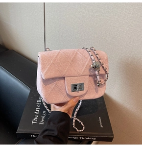 Detail of pink quilted tweed bag with silver metal turn-lock and ball chain strap