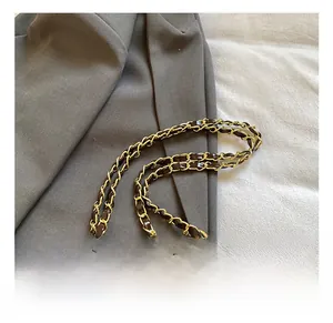 Close-up of golden metal chain strap and quilted leather texture on brown crossbody bag