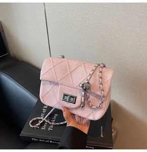 Detailed shot of pink tweed handbag with diamond stitching and silver chain strap